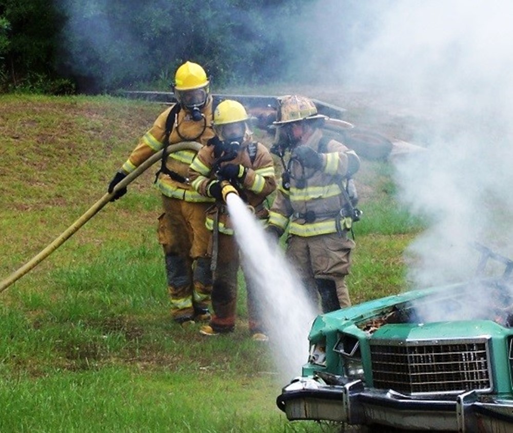 Firefighters putting out a car fire